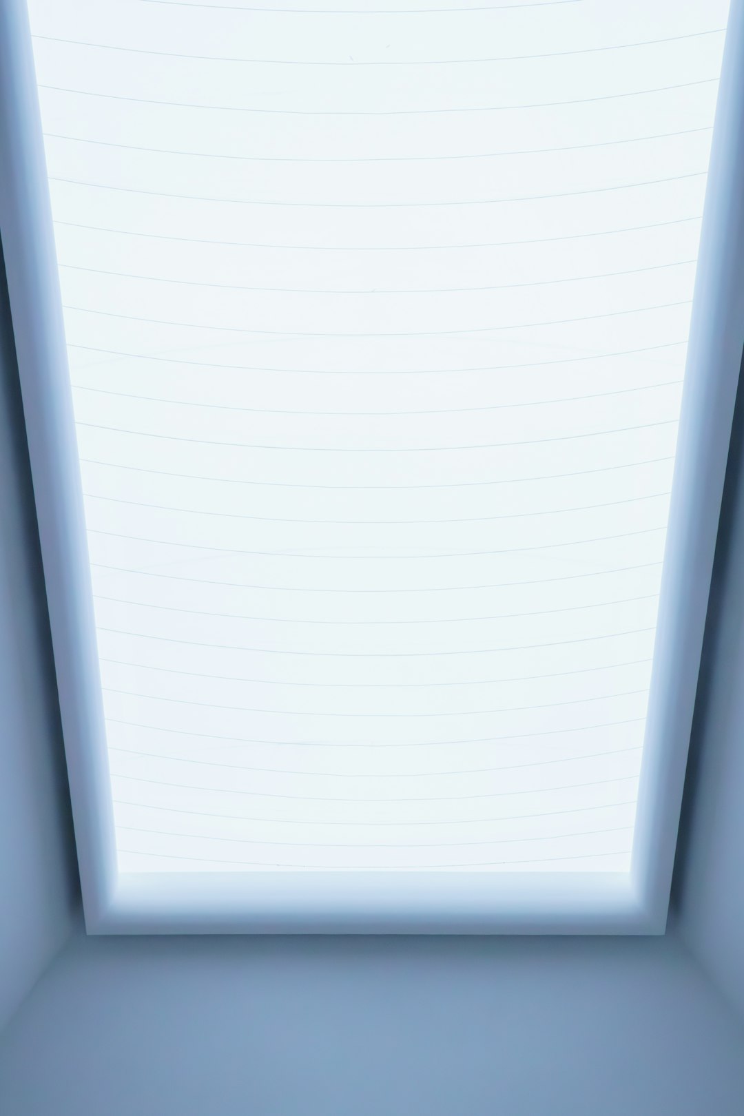 a room with a skylight and a bed in it
